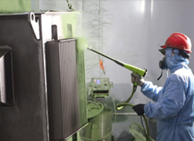 Worker applying anti-corrosion coating to a transformer